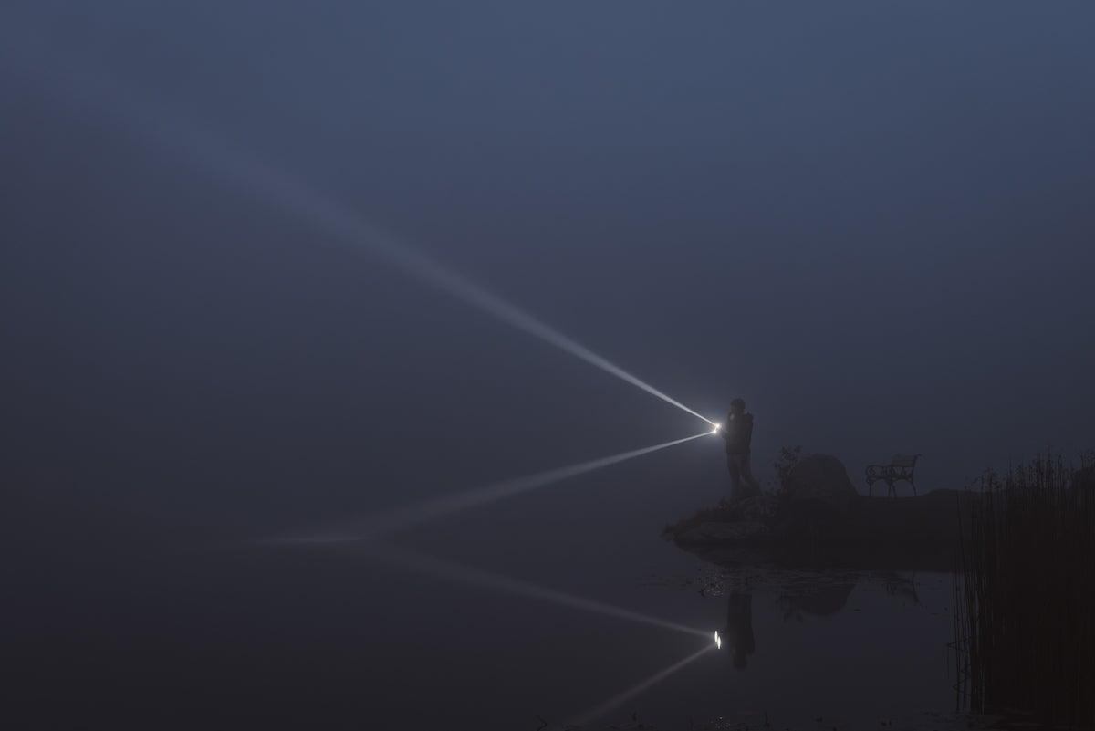 A foggy night with a person standing on a dock